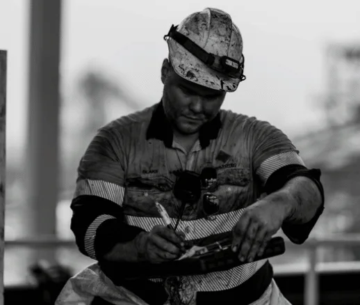 Worker in hi-vis completing paperwork on site